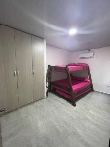 圣玛尔塔Hostal el ebenezeer的客房设有2张双层床和粉红色床单。