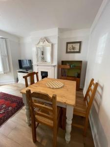 布莱顿霍夫Homely garden apartment, newly refurbished - sleeps four的一间带木桌和椅子的用餐室