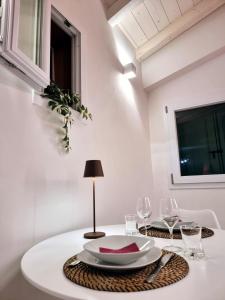 博洛尼亚Garden Suite的一张带盘子和酒杯的白桌