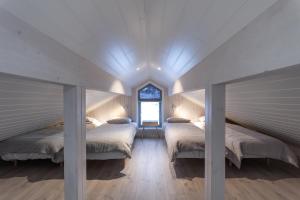 StraumsjøenVikran Seaside Lodge的带三张床和窗户的客房