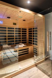 格齐斯Business Hotel Maier - kontaktloser Check-in的一间设有玻璃墙的桑拿浴室的房间