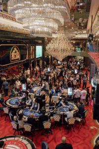 巴统Grand Bellagio Batumi Convention & Casino Hotel的坐在大房间里桌子上的一群人