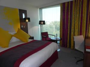 蒙彼利埃皇冠假日佩里尔峰库尔姆酒店的酒店客房设有床和窗户。