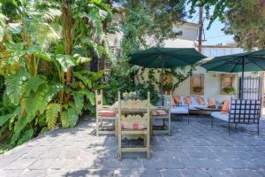 拜特龙La Madrague 3 Bedroom Villa with Garden in Batroun的一个带桌椅和遮阳伞的庭院