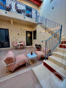 勒格罗-迪鲁瓦Villa Chiesa的客厅设有粉红色的椅子和楼梯