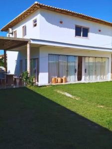 塞古罗港Casa nova completa a poucos passos da Praia do Mutà的前面有草坪的白色房子