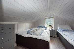 GimsøyModerne hytte på fantastiske Gimsøy i Lofoten的一间卧室设有两张床和窗户。