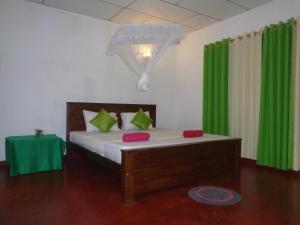 陶尔佩Green Valley Home stay的一间卧室配有一张带绿色窗帘的床和一张桌子