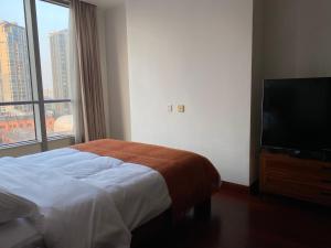 上海上海市中心怡水豪庭公寓的一间卧室配有一张床和一台平面电视