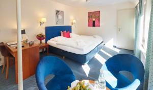 霍恩-巴特迈恩贝格Waldhotel Bärenstein的酒店客房,配有床和蓝色椅子