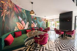 安塔利亚巴塞尔酒店 的一间设有绿色沙发和红色椅子的客房