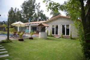 科恰班巴Casa de Campo Solar Tere的一个带游泳池和遮阳伞的庭院