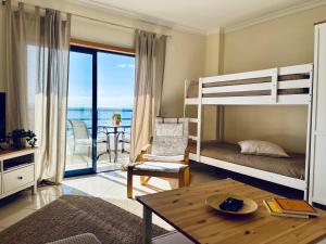 奎特里拉Pérola do Algarve的一间带双层床的卧室和一间带阳台的客厅