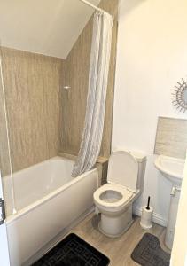 巴塞尔顿Impeccable 2-Bed House in Basildon的浴室配有卫生间、浴缸和水槽。