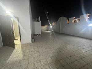 Al ‘Awālī8 Luxury housing شقة فاخر的一间铺有瓷砖地板的客房,晚上设有一扇门