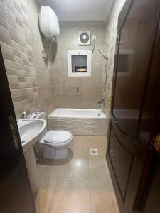Al ‘Awālī8 Luxury housing شقة فاخر的浴室配有卫生间、浴缸和水槽。