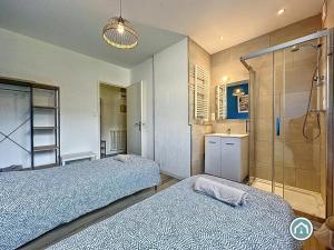 布雷斯特Ty Massillon ravissant appartement deux chambres的配有2张床的客房设有淋浴和浴室。