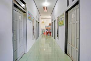 外南梦OYO Life 92937 Kost Putri Sarkara Syariah的学校的走廊,有白色的墙壁和门