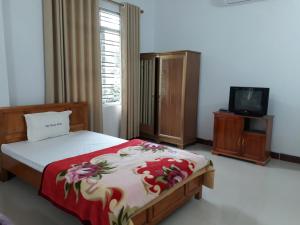 Bảo LạcKhách sạn Việt Hoàng的一间卧室配有一张床和一台电视。