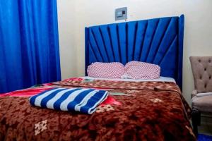 蒙巴萨Ziggon villa mtwapa的一张带蓝色床头板和枕头的床