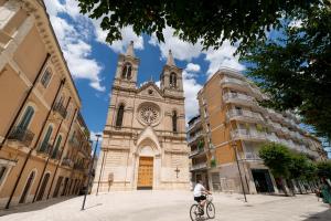 焦亚德尔科莱Santa Lucia Affittacamere的骑着自行车在教堂前的人