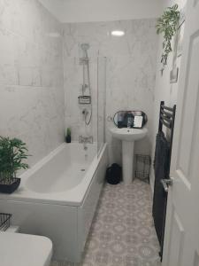 巴恩斯利Cosy home in Barnsley centre的白色的浴室设有浴缸和水槽。