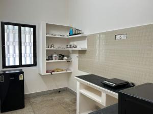 钦奈HOMESTAY - AC 1 BHK NEAR AlRPORT的一个带书桌的厨房和窗户