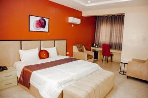 阿布贾Nexus Xpress Hotel的一间卧室配有一张带橙色墙壁的大床