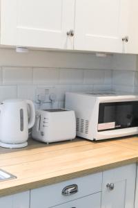巴特利Cosy house in West Yorkshire的厨房柜台配有微波炉和烤面包机。