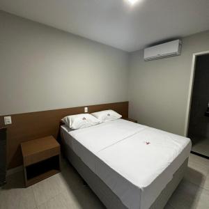 萨尔瓦多ONIX AGUAS CLARAS的卧室配有白色的床和空调