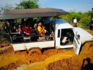 达瓦拉维KANDULA - Infrant Of the National Park -的一群人,在一辆白色汽车后面,在泥 ⁇ 中