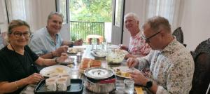 科钦Gerards Home stay Fortkochi的一群坐在桌子旁吃食物的人