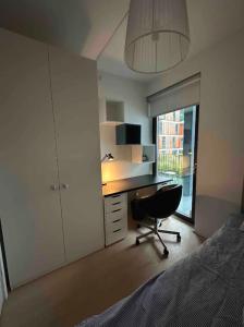 斯德哥尔摩Shared Modern apartment with pets by the waterfront的一间卧室配有书桌、椅子和床