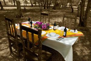 姆托瓦姆布NSYA CAMP MANYARA的一张桌子,上面有黄色的桌布和葡萄酒瓶