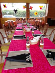 纳库鲁Brownies Deluxe的长桌,带粉红色桌布和餐巾
