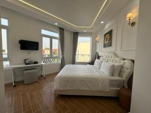 朱笃Paris Hotel Châu Đốc的卧室配有白色的床和电视。
