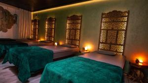 温特贝格布拉邦德度假酒店的客房设有两张带绿床单和窗户的床。