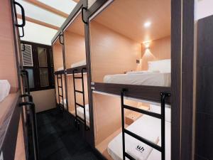新加坡Wink at Perak Road的带三张双层床和镜子的客房
