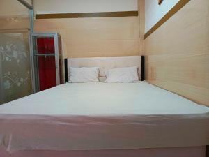 肯达利OYO 93278 Wisma Syariah Lahundape的红色门的房间一张大白色的床