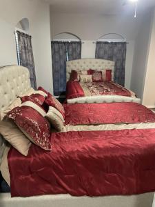 休斯顿Huge one bedroom with 2 Queen size beds的一间卧室配有两张带红色毯子和枕头的床