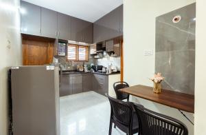 班加罗尔RZ Residency的厨房配有桌子和冰箱