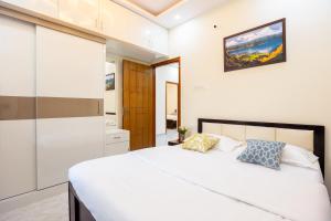 班加罗尔RZ Residency的卧室配有一张带两个枕头的大白色床