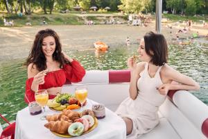 波拉齐克VIP JACHT的两个女人坐在船上吃食物