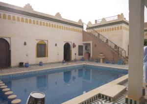 梅尔祖卡Casa laman的一座带楼梯的建筑旁的游泳池