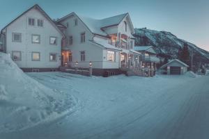 特罗姆瑟Villa Havblikk Tromsø的雪覆盖街道上的一座大房子