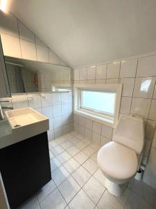 斯塔万格Central family twinhouse的一间带卫生间、水槽和窗户的浴室