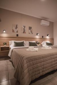 维拉卡洛斯帕兹Hotel Libertad的一间卧室配有一张大床和毛巾