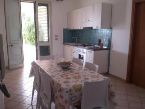 帕洛港Appartamento Santangelo的厨房配有桌椅和桌布