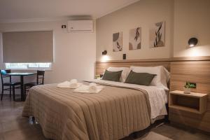 维拉卡洛斯帕兹Hotel Libertad的一间卧室配有一张大床和两条毛巾