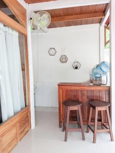 吉利特拉旺安Rascal House Gili Trawangan的客房设有两张凳子和一张木桌